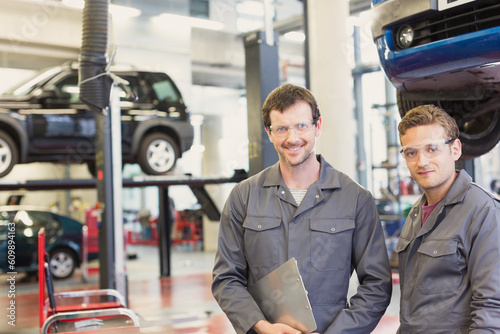 Obraz na plátně Portrait confident mechanics in auto repair shop