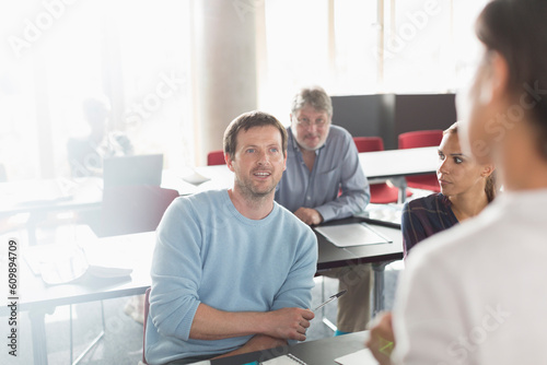 Professor and students talking in adult education classroom