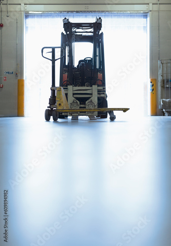 Forklift parked in warehouse loading dock doorway