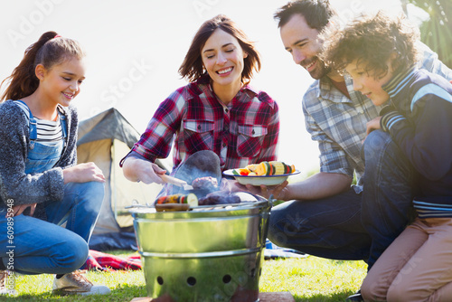Family barbecuing at campsite grill photo