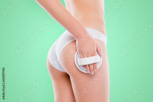 Cropped close up photo of sportive booty ass in cotton bikini hand holding massage brush applying scrub isolated on white background photo