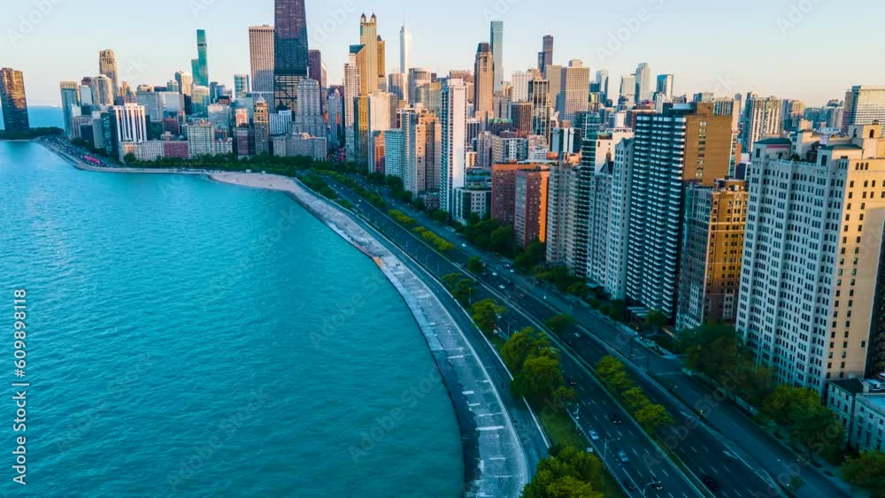 Aerial hyper lapse footage of Chicago lake front during late evening. Cars and pedestrians speed by as the sun slowly sets in the back ground. the beautiful skyscraper showcases the city architecture.