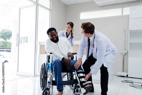 Doctor with broken leg patient sitting in a wheelchair.
