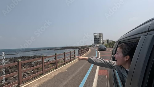 해변도로를 드라이브 하며 창밖으로 팔을 내미는 여성