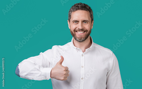 photo of mature businessman with stubble show thumb up. mature businessman isolated on blue
