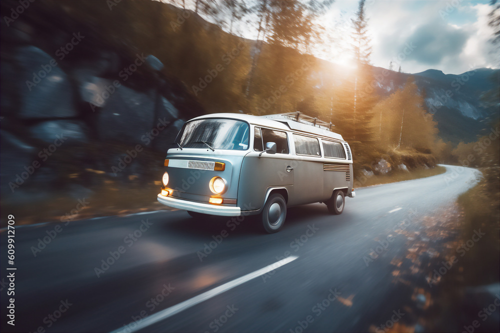 Camper van driving on a mountainous road at dawn