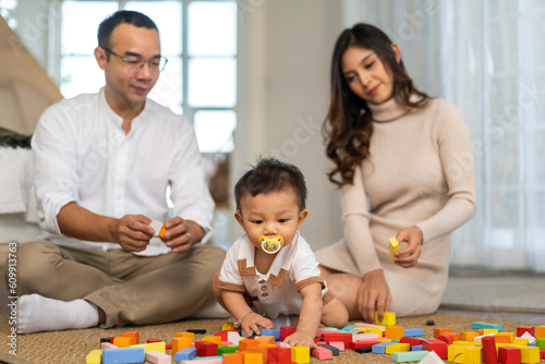Portrait of enjoy happy love family asian father and mother playing with adorable little asian baby.newborn, infant.dad touching with cute son moments good time play toy.Love of family