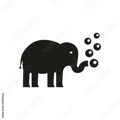 An elephant blowing soap bubbles from his trunk.