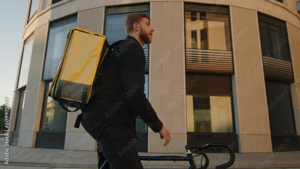 The courier looks at the delivery address in the phone. Modern business center in the background The courier looks at the delivery address in the phone. Modern business center in the background
