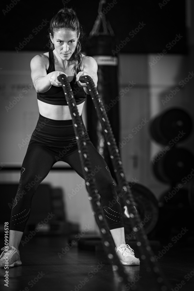 Agility training, woman exercising with rope in a gym.