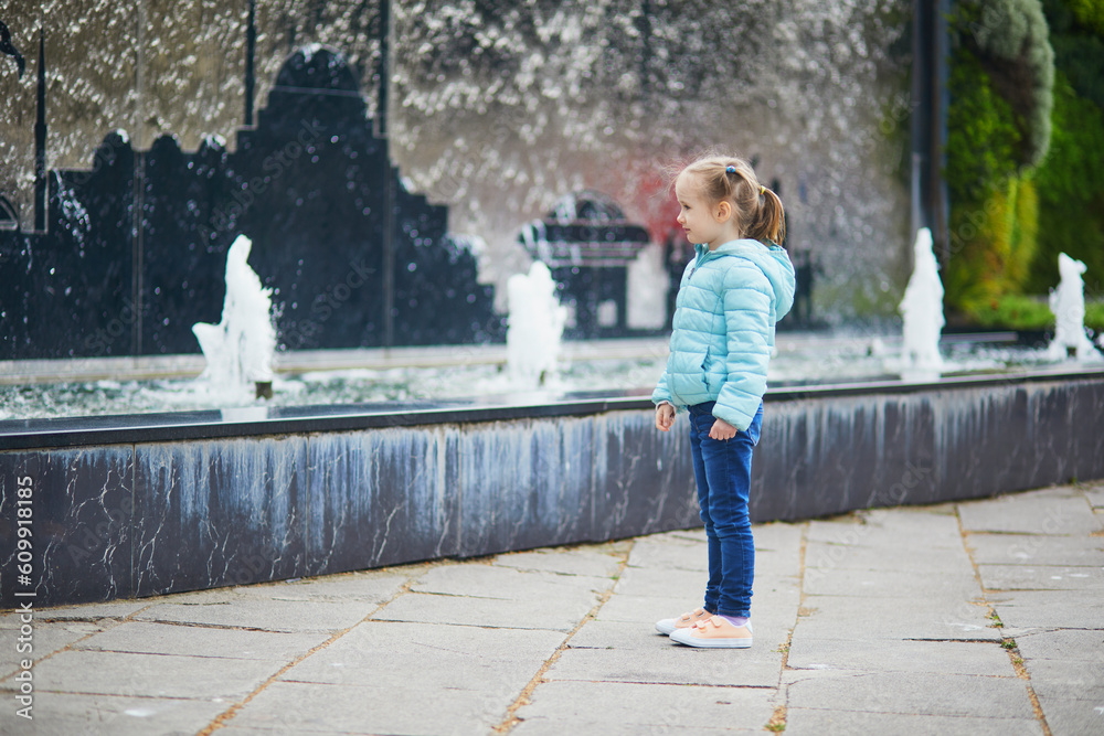 Preschooler girl having fun near urban fountain in Uskudar district on Asian side of Istanbul, Turkey