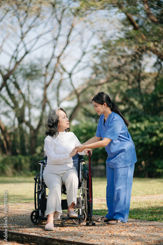 Elderly asian senior woman on wheelchair with Asian careful caregiver. Nursing home hospital garden concept... © Nuttapong punna