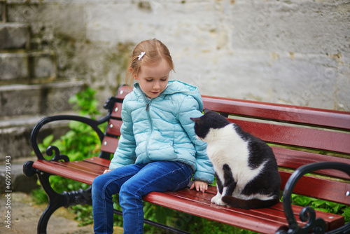 preschooler girl caressing a cat in Uskudar district on Asian side of Istanbul, Turkey