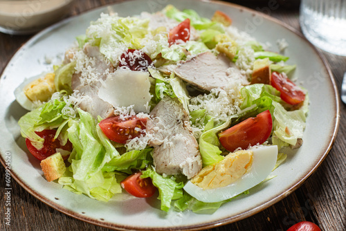 Appetizing Caesar salad in a plate on a wooden table