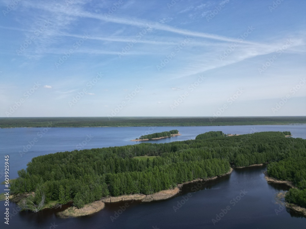 Drone view. The islands are covered with greenery. On the spills of the spring Volga.