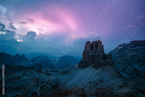 Head tourch trails of mountaineers hiking on dolomite hiking trails with a thunder storm in the background. Tre Cime, Dolomites, South Tirol, Italy, Europe.