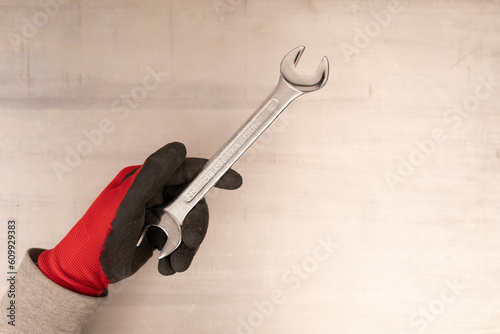 Man's hand holds a wrench i...