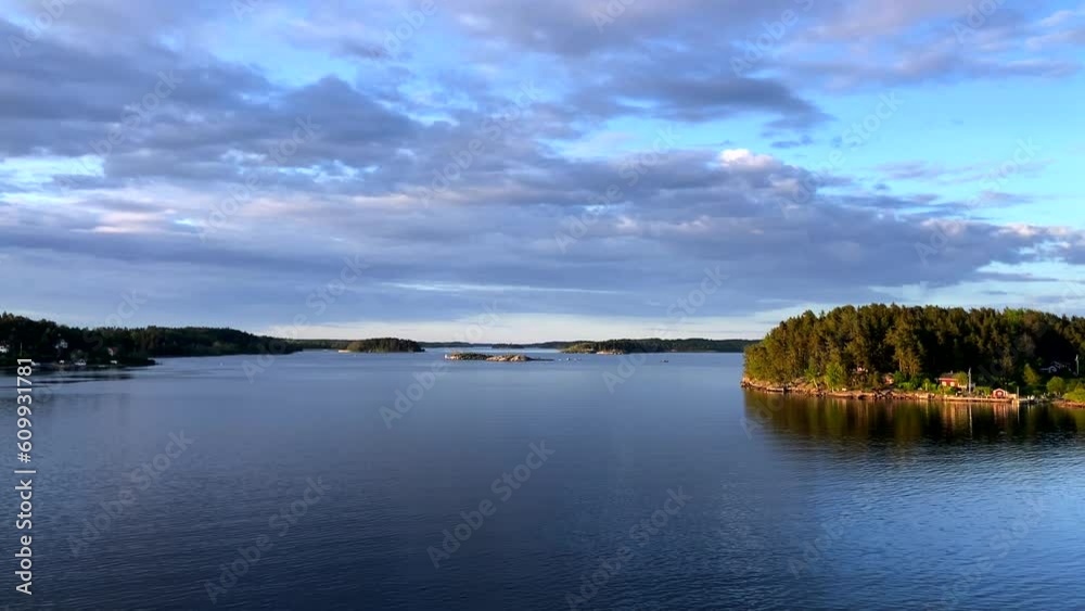 Moving along the bay towards the open sea among small islands. Real green nature, beautiful azure water. Water surface. Real Norwegian nature Moving along the bay towards the open sea among small islands. Real green nature, beautiful azure water. Water surface. Real Norwegian nature