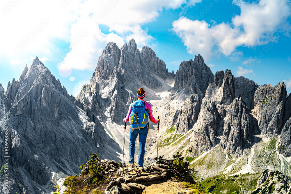 Athletic woman enjoys view on Cadini group from epic view point in the morning. Tre Cime, Dolomites, South Tirol, Italy, Europe.