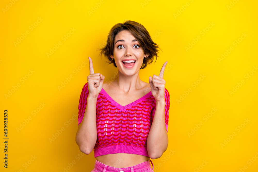 Photo of impressed overjoyed girl dressed off shoulder shirt indicating at empty space discount isolated on yellow color background Photo of impressed overjoyed girl dressed off shoulder shirt indicating at empty space discount isolated on yellow color background