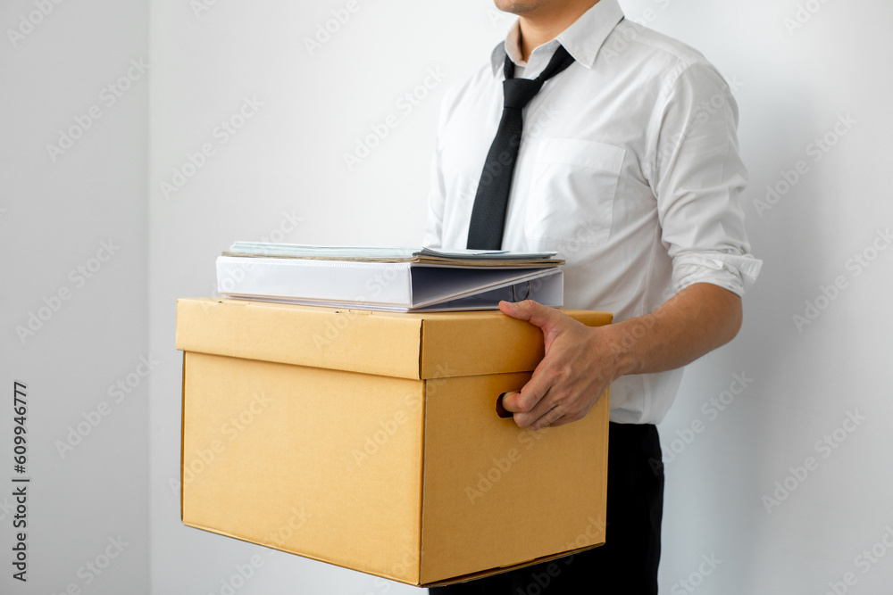The male employee clutched a box filled with his personal belongings, his decision to resign from the job reflecting of resolve, and a resolute belief in following his own path. The male employee clutched a box filled with his personal belongings, his decision to resign from the job reflecting of resolve, and a resolute belief in following his own path.