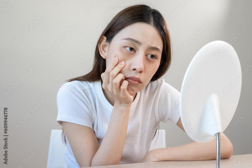 Sleepless Asian woman looking her face in the mirror and worry about dark circles under eyes Sleepless Asian woman looking her face in the mirror and worry about dark circles under eyes