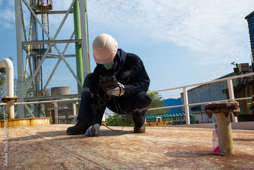 Tester male worker are for inspection ultrasonic thickness measurement roof plate on storage tank photo