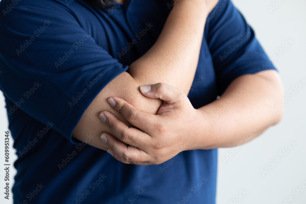 Middle aged man suffering from elbow joint pain, concept of tennis elbow or golfer’s elbow syndrome, gouty pain, rheumatoid, arthritis, osteoporosis