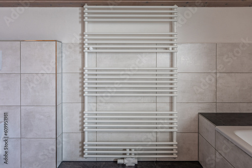 White towel heater in a modern white and grey bathromm