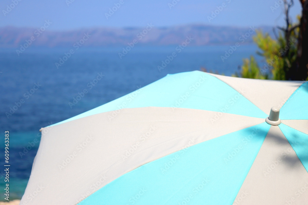 Colorful parasol on the beach, on island Korcula, Croatia. Sunny summer day. Selective focus.