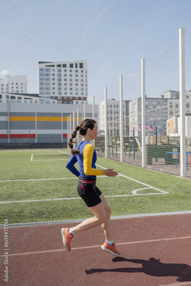 Running young woman in sportswear on stadium Running young woman in sportswear on stadium
