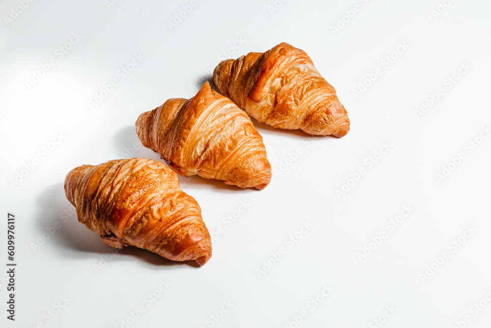 Three croissants on a white background, side view with space for text