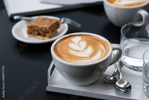 Wallpaper Mural A cup of capucciono with a slice of cake on black table   Torontodigital.ca