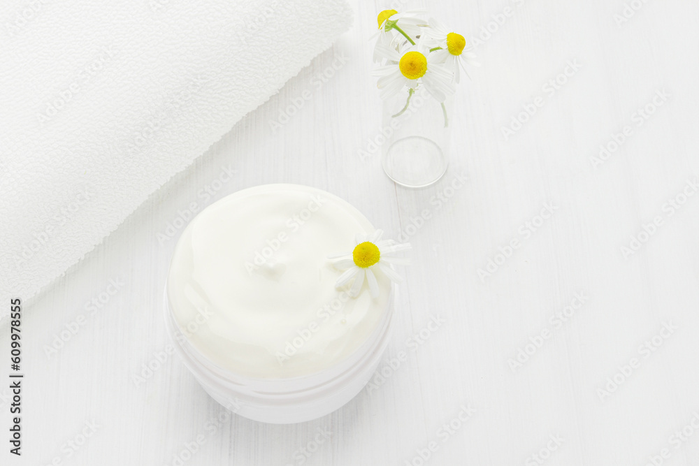 White nourishing cream with chamomile in a white jar. White nourishing cream with chamomile in a white jar.