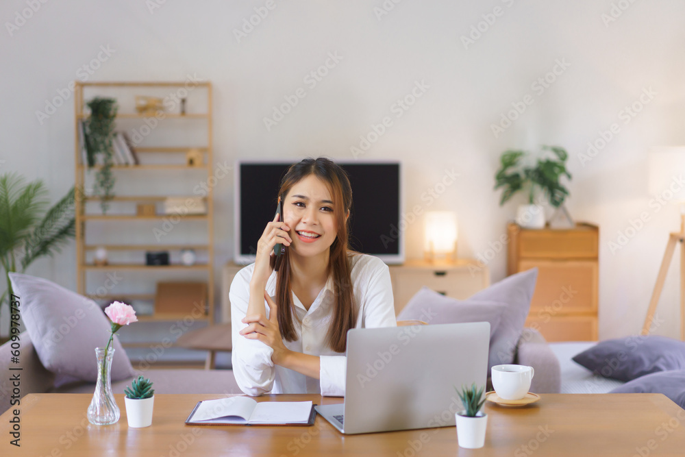 Relaxing time concept, Women talking on smartphone and working on laptop at modern home office Relaxing time concept, Women talking on smartphone and working on laptop at modern home office