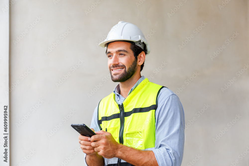 Male engineer in green reflective vest and hard hat using phone construction worker communication Male engineer in green reflective vest and hard hat using phone construction worker communication