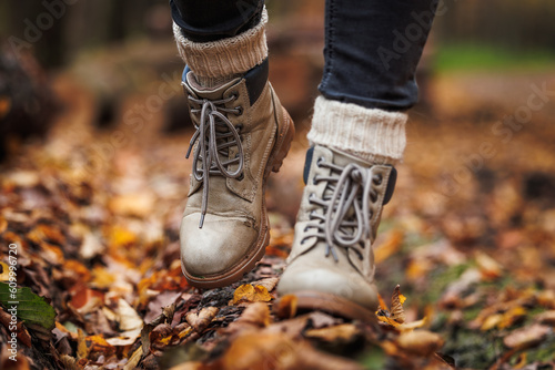 Leather hiking boot with knitted socks. Walking in autumn forest photo