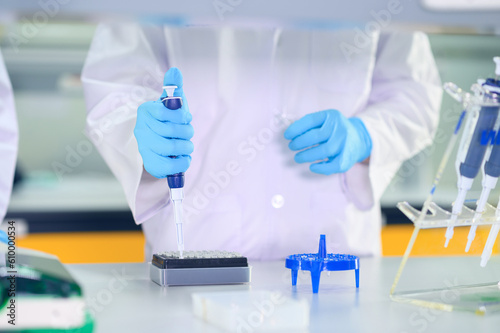 Male scientist working at the laboratory. Cloud up medical hand using micro pipette for test analysis. Scientific Lab for Medicine, Biotechnology Researchers.