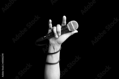 microphone in hand of singer raised his hand all the way up in live concert. hand sign mean love, love to sing concept