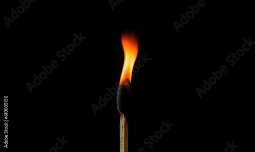  a matchstick with a match lite on top of it in the middle of a black background with a red and yellow match between the two matches.  generative ai © Olga