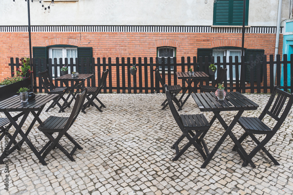 Wooden empty tables and chairs for seating and eating in cafe or restaurant outdoors Wooden empty tables and chairs for seating and eating in cafe or restaurant outdoors