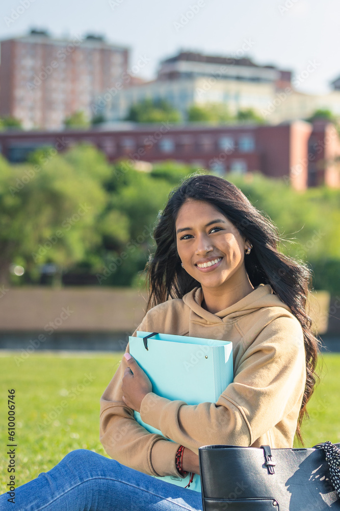 Obraz premium young girl with a blue folder, walking and studying on the campus of the university, hight school or institute.