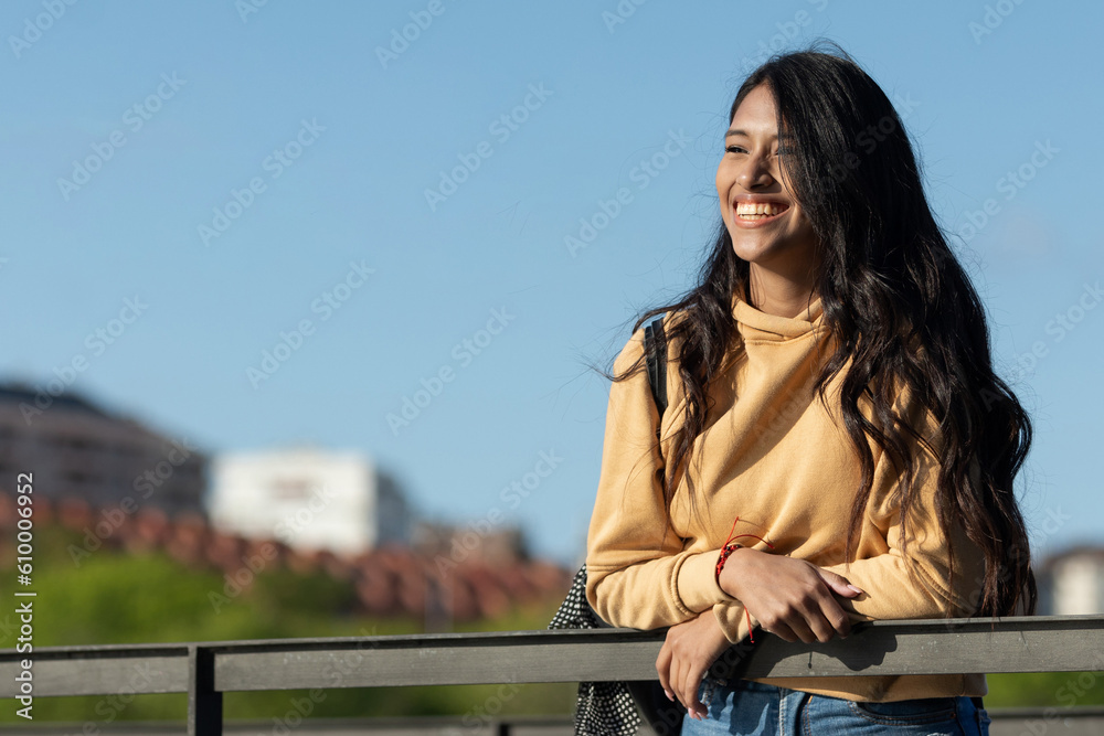 Happy and smiling woman walking through a city park