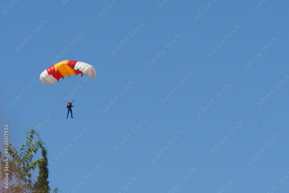 Parachutist man flies with colourful paraglider Parachutist man flies with colourful paraglider