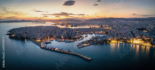 Aerial view of the illuminated Piraeus district in Athens, Greece, with Zea Marina, Kastella hill and the ferry boat harbour in the background during dusk photo