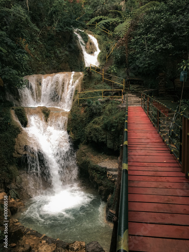 Beautiful waterfall with red wooden bridge on Mudal river, Kulon progo, Yogyakarta, Indonesia photo
