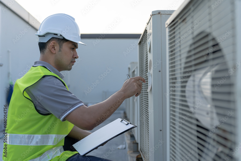 Asian maintenance engineer works on the roof of factory. contractor inspect compressor system and plans installation of air condition systems in construction. Checklist, inspector, control Asian maintenance engineer works on the roof of factory. contractor inspect compressor system and plans installation of air condition systems in construction. Checklist, inspector, control