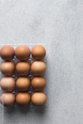 Top view of a crate of eggs on a marble surface, Eggs in a transparent plastic crate, organic eggs on a table 