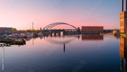 Sunset over the tranquil Providence River with arching highway bridge, moored boats, and water reflections in Rhode Island