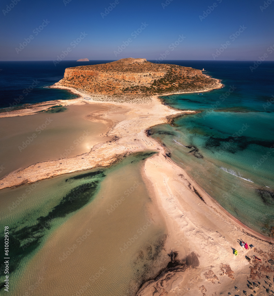Majestic Morning at Balos, Crete: Serene turquoise waters caress the white sandy beach, embraced by dramatic cliffs under the golden morning sunlight